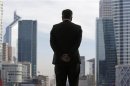 A Businessman is silhouetted as he stands under the Arche de la Defense in the financial district west of Paris
