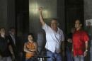 Former cabinet chief of staff Jose Dirceu gestures to supporters as he turns himself in to federal police in Sao Paulo