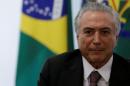 Brazil's interim President Michel Temer looks on near Chief of Staff Minister Eliseu Padilha (L) during a meeting with unionists at the Planalto Palace in Brasilia