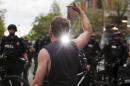 A demonstrator swears at police while holding a middle finger up during an anti-capitalist protest in Seattle