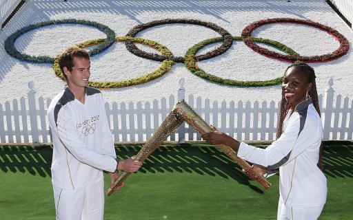 Britain's Andy Murray and Venus Williams of the U.S. pose  with the Olympic Torch on Murray Mound at the All England Lawn Tennis Club before the start of the London 2012 Olympic Games in London