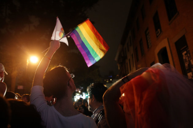 NEW YORK, NY - JUNE 24:  A reveler waves a gay pride flag in front of the historic gay bar The Stonewall after the passing of a bill legalizing gay marriage in New York State on June 24, 2011 in New York City. New York State now joins Connecticut, Massachusetts, New Hampshire, Vermont, Iowa and Washington, D.C. in legally recognizing gay marriage. (Photo by Spencer Platt/Getty Images)
