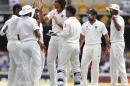 India's Ishant Sharma, center, celebrates with his teammates after he got the wicket of Australia's David Warner during their play on day four of the second cricket test in Brisbane, Australia, Saturday, Dec. 20, 2014. (AP Photo/Tertius Pickard)