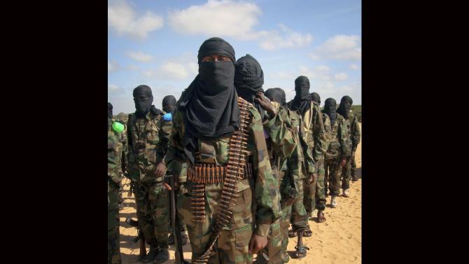 FILE - Armed members of the militant group al-Shabab attend a rally on the outskirts of Mogadishu, Somalia in this Feb. 13, 2012 file photo. Police officials say al-Shabab militants from Somalia have hijacked a bus Saturday Nov. 23, 2014 in northern Kenya and killed 28 non-Muslims on board.  (AP Photo)