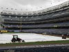 A tractor and other equipment stand on the tarp to prevent it from blowing away in high winds after Tuesday night's baseball game between the New York Yankees and the Toronto Blue Jays was postponed because of inclement weather, at Yankee Stadium in New York, Sept. 18, 2012. (AP Photo/Kathy Willens)