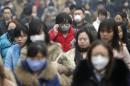 Commuters wearing masks make their way amid thick haze in the morning in Beijing