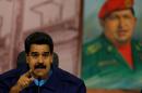 Venezuela's President Nicolas Maduro speaks next to a painting of the late Hugo Chavez, during a news conference at Miraflores Presidential Palace in Caracas, Venezuela, Friday, Feb. 21, 2014. Speaking Friday to international media, Maduro called out what he said was a "campaign of demonization to isolate the Bolivarian revolution." (AP Photo/Fernando Llano)