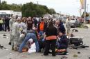 People attend to the injured at the scene of a car crash after a car drove into a homecoming parade at Oklahoma State University in Stillwater