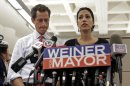 New York mayoral candidate Anthony Weiner, left, listens as his wife, Huma Abedin, speaks during a news conference at the Gay Men's Health Crisis headquarters, Tuesday, July 23, 2013, in New York. The former congressman says he's not dropping out of the New York City mayoral race in light of newly revealed explicit online correspondence with a young woman. (AP Photo/Kathy Willens)