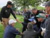 Phil Mickelson, left, consoles a fan while she is tended to after being struck in the head by Mickelson's approach shot on the 16th hole during the third round of the Wells Fargo Championship golf tournament at Quail Hollow Club in Charlotte, N.C., Saturday, May 4, 2013. (AP Photo/Chuck Burton)