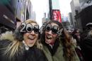 Veronica Boshen and Brittany Wells, of Allentown, Pa., pose for a photo with their 2014 glasses while waiting for the celebration to begin in Times Square on New Year's Eve, Tuesday, Dec. 31, 2013, in New York. (AP Photo/Kathy Willens)
