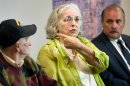 Jan Cooper, 72, talks to the media as her husband Bob, 85, left, and OC Sheriff's spokesman Jim Amormino listen during a news conference at the Sheriff's Department station in Stanton on Tuesday, June 11, 2013. Jan Cooper showed where the Sheriff's estimated the bullet traveled, based on the size of the suspect and the damage to her sliding glass door, when she scared off an intruder at her home in unincorporated Anaheim on Sunday, June 9, by firing a shot from her .357 Magnum during the attempted break-in. The bullet went through the frame of her sliding glass door and just missed the intruder. The suspect, Brandon Alexander Perez, is in custody. (AP Photo/The Orange County Register, Paul Bersebach) MANDATORY CREDIT THE ORANGE COUNTY REGISTER, LA TIMES, MAGS OUT