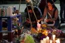 A woman places flowers at a makeshift shrine in honor of Nohemi Gonzalez at California State University in Long Beach, California