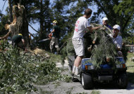 Workers use a golf cart to carry branches from a tree that fell onto the 14th fairway at Congressional Country Club in Bethesda, Md., Saturday, June 30, 2012, after a strong storm blew through overnight. The AT&T National golf tournament was postponed to allow workers to clear the course. (AP Photo/Patrick Semansky)