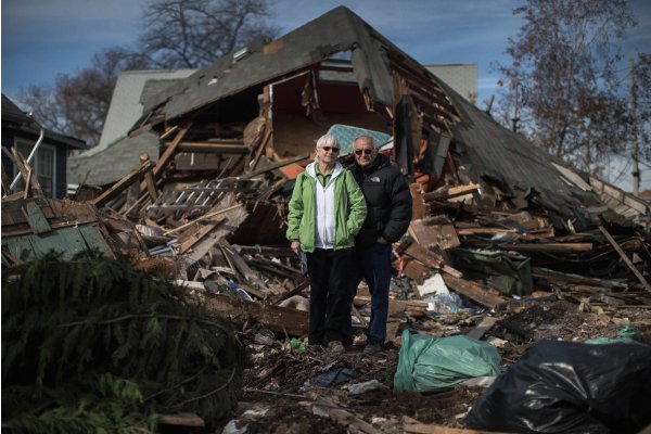 Sheila and Dominic Traina pose for photograph amid remains of house demolished by Hurricane Sandy in New Dorp Beach