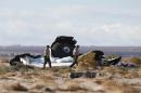 Sheriff's deputies look at a piece of debris near the crash site of Virgin Galactic's SpaceShipTwo near Cantil
