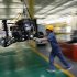 An employee pushes a car engine at a Geely Automobile assembly line in Cixi