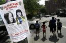 This Tuesday, July 23, 2013, photo shows a poster soliciting information regarding an unidentified body near the site where the body was found in New York. In a dramatic break in a cold case more than two decades old, investigators used DNA to identify the mother of a dead child known only as Baby Hope, police said Tuesday, Oct. 8, 2013. Police Commissioner Raymond Kelly declined to discuss the case further as investigators try to determine the circumstances of the 3- to 5-year-old girl's death. The case dates to July 23, 1991, when a road worker smelled something rotting and discovered the girl's remains inside a picnic cooler along the Henry Hudson Parkway. Her body was unclothed and malnourished and showed signs of possible sex abuse. Detectives theorized at the time that she had been suffocated before being dumped like garbage on a grassy incline. They estimated she was dead six to eight days before the cooler was found. (AP Photo/Seth Wenig)