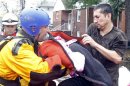 A resident passes his baby to an emergency personnel as they are rescued from flood waters brought on by Hurricane Sandy in Little Ferry