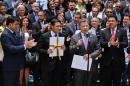 Colombian President Juan Manuel Santos (2-R) delivers a speech as the president of the National Congress, senator Mauricio Lizcano (C) holds a copy with the final text of the peace agreement with FARC guerrillas, in Bogota on August 25, 2016