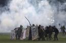 Protesters shield themselves as police fire tear gas outside Congress, where senators planned to vote on a spending cap bill and the lower Chamber of Deputies was considering controversial anti-corruption legislation, in Brasilia, Brazil, Tuesday, Nov. 29, 2016. Brazil, home to Latin America's largest economy, is suffering its worst recession in decades. (AP Photo/Eraldo Peres)