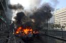 Flames blaze from vehicles at the scene of an explosion in Beirut, Lebanon, Friday, Dec. 27, 2013. A strong explosion has shaken the Lebanese capital, sending black smoke billowing from the center of Beirut. The blast went off a few hundred meters (yards) from the government headquarters and parliament building. (AP Photo/Bilal Hussein)