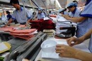 Workers wrap up shirts at a garment factory in Hanoi in 2008. Communist Vietnam -- which produces clothes for disposable fashion industry giants Zara, Mango and H&M -- shows it is possible to have "extremely strong" labour laws, fair wages and a healthy garment industry, experts say
