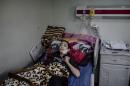 In this Wednesday, Dec. 21, 2016 photo, Abdul-Hameed, 15, lies in a hospital bed at West Emergency Hospital in Irbil, Iraq. Abdul-Hameed was injured in an Islamic State militant mortar attack in Mosul. The 15-year-old Iraqi boy was lying in a hospital bed recovering from his wounds when his brother brought him the news: Their father, a few rooms over, had just died from the shrapnel lodged in his head from the same Islamic State group mortar attack that hit their family in Mosul. (AP Photo/Cengiz Yar)