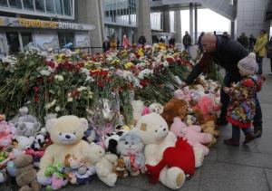 A man and his daughter put flowers and a toy at an&nbsp;&hellip;