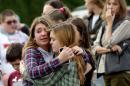 Two girls hug at Shoultes Gospel Hall church where families are reuniting after an active shooter situation at Marysville-Pilchuck High School in Marysville, Washington