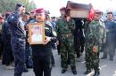 Iraqi military officers carry the coffin of a comrade -- who was killed during clashes in the western Anbar province -- during his funeral in the city of Nasiriyah, on December 31, 2013