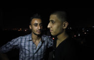 Mohammed Hanouna, 18, left, looks at his friend Ayman al-Sayed, 19, right, with his hair cut, in Gaza City, Sunday, April 7, 2013. Al-Sayed used to have shoulder-length hair but says he was grabbed by Hamas police in a sweep along with other young men with long or gel-styled spiky hair last week, and that police shaved everyone's head. Hanouna still wears the hair-style that can now get young men in trouble in Gaza, during the Islamic militants latest attempt to impose their hardline version of Islam on Gaza. (AP Photo/Adel Hana)