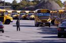 Boston school busses sit idle behind a chain link fence at Veolia Transportation, the city's school bus contractor, in Boston, Tuesday, Oct. 8, 2013. About 600 school bus drivers have gone on strike affecting most of the school district's 33,000 students. (AP Photo/Stephan Savoia)