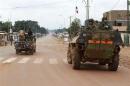 A French military vehicle patrols past Seleka soldiers during fighting between Muslim and Christian militias in Bangui