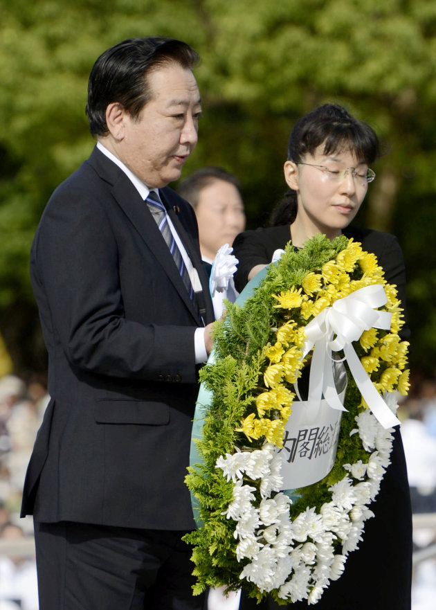 Japan&#39;s Prime Minister Yoshihiko Noda carries the wreath to offer in front of the cenotaph dedicated to the victims of the atomic bombing at the Peace Memorial Park in Hiroshima, western Japan, Mo
