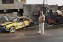 An Iraqi man inspects his car destroyed in a suicide car bomb in the Baghdad al-Jadidah district, Iraq, Friday, Nov. 8, 2013. Officials in Iraq said a series of attacks, including a bomb attack have killed and wounded civilians on Thursday. (AP Photo/Khalid Mohammed)
