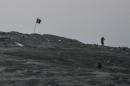 Islamic State (IS) militants stand near their flag on Tilsehir hill in Syria near the Turkish border on October 23, 2014