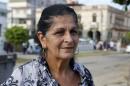 Elba Gil, 61, housewife, poses for a photo in Havana, Cuba, Wednesday, July 1, 2015. Eleven years ago, Gil cried for a week when her daughter left to live in the United States. As her last child remaining on the island now prepares to make the same move soon with her own family, Gil feels more nostalgic than anything. That's because improved political ties are making it easier for families divided by the Florida Straits to stay in touch. (AP Photo/Desmond Boylan)