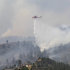 A helicopter drops water on trees burning behind homes on the High Park wildfire near Fort Collins, Colo., on Monday, June 11, 2012. The wildfire is burning out of control in northern Colorado, while an unchecked blaze choked a small community in southern New Mexico as authorities in both regions battled fires Monday.  (AP Photo/Ed Andrieski)