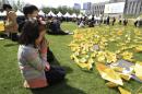 A girl prays in front of paper ships bearing messages for the victims of the sunken ferry Sewol at a group memorial altar in Seoul, South Korea, Monday, May 5, 2014. More than 300 people are dead or missing in the water off the southern coast in the disaster that caused widespread grief, anger and shame. (AP Photo/Ahn Young-joon)