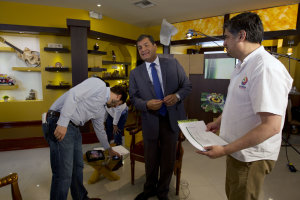 Ecuador's President Rafael Correa, center, jokes as …