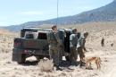 Tunisian soldiers use a sniffer dog as they look for landmines in the Mount Chaambi region where the Tunisian army has been tracking militants