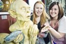 Handout photo shows visitors posing next to a sculpture of the J. R. R. Tolkien character Gollum at the Weta Cave museum in Wellington