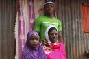 Latifah Naiman Mariki, widow of the late Haji Lukindo, with two of her children Juma Lukindo, 20, and Shamim Lukindo, 7, outside their house in Nairobi, Kenya, Friday, Aug. 2, 2013. An American diplomat who police say was speeding crossed the center line in his SUV and rammed into a full mini-bus, killing a father of three whose widow is six months pregnant, officials said Friday. Latifah Naiman Mariki, 38, and whose husband was killed in the crash, was almost evicted from her house this week after her landlord demanded rent. Mariki's deceased husband, Haji Lukindo, was the family's only source of income. Mariki told The Associated Press that neither the American driver nor anyone at the U.S. Embassy has contacted her, and she doesn't know how she will provide for her soon-to-be-born child and three children, ages 20, 10 and 7. (AP Photo/Khalil Senosi)