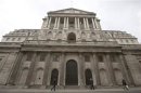 Pedestrians walk past the Bank of England in the City of London