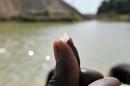 A diamond prospector holds up a diamond stone on April 28, 2012, in Koidu, the capital of the diamond-rich Kono district, in eastern Sierra Leone, on April 28, 2012