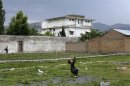 A boy plays with a tennis ball in front of the compound in Abbottabad