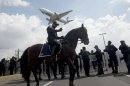 Police stand guard as an airliner lands at the Benito Juarez international airport in Mexico City on August 23, 2013