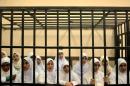 Egyptian women supporters of ousted President Mohammed Morsi stand inside the defendants' cage in a courtroom in Alexandria, Egypt, Wednesday, Nov. 27, 2013. An Egyptian court has handed down heavy sentences of 11 years in prison to 21 female supporters of the ousted Islamist president, many of them juveniles, for holding a protest. (AP Photo/Amira Mortada, El Shorouk Newspaper) EGYPT OUT