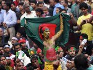 A man holds a Bangladesh national flag as he chants a slogan before a mass funeral as the body of Rajib Haider, an architect and blogger who was a key figure in organising demonstrations, arrives at Shahbagh intersection in Dhaka in this February 16, 2013 file photo. REUTERS/Andrew Biraj/Files
